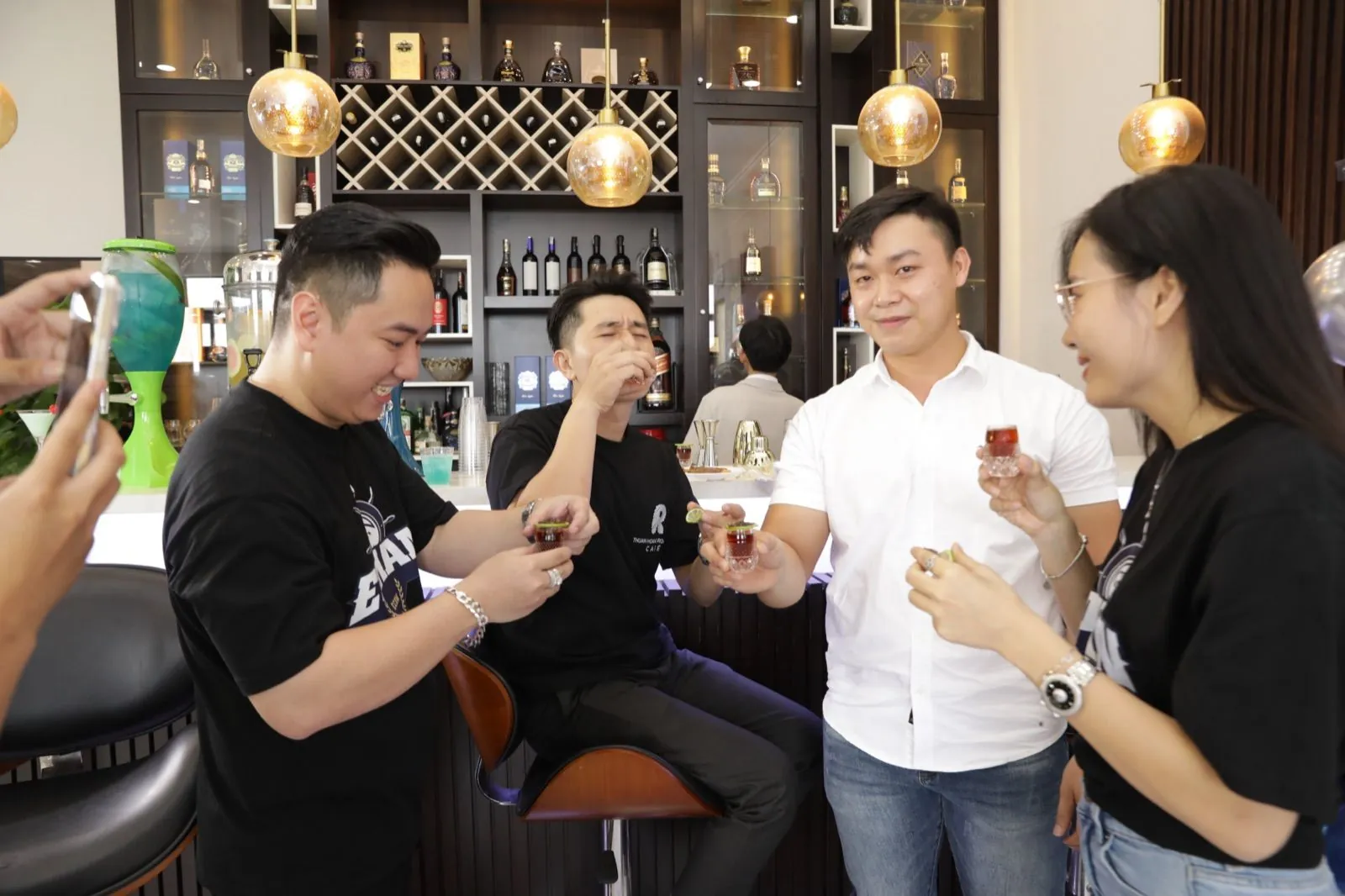 Các thành viên Ethan cụng ly rôm rả bên quầy bar mừng sự kiện thành công tốt đẹp